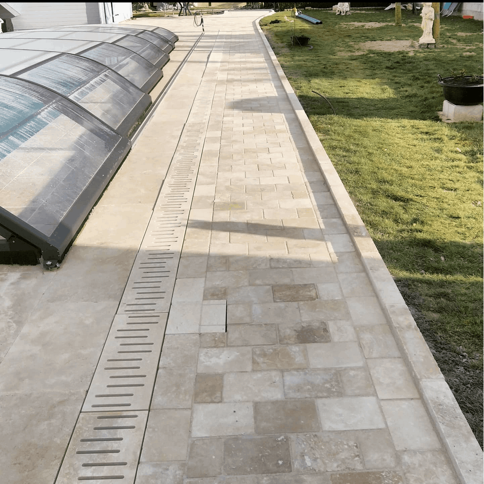 Réalisation d'une terrasse en travertin pour une piscine enterrée.