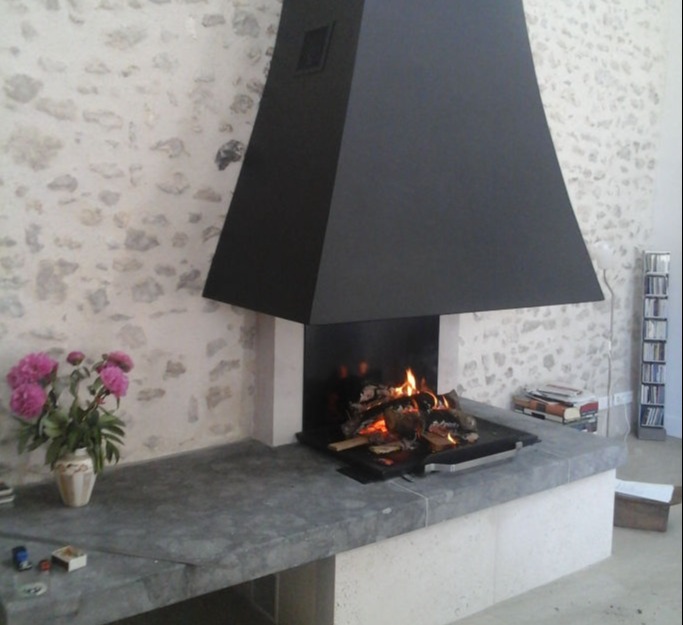 Cheminée-poêle avec récupérateur de chaleur intégrée dans une cheminée de style contemporain Pierre et Acier