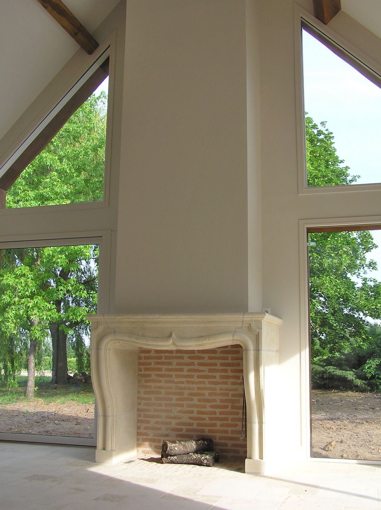 Cheminée classique romantique en pierre de taille et briquette dans une habitation contemporaine